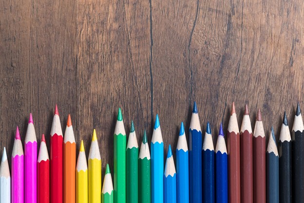 Multicoloured pencil crayons against a dark wood background